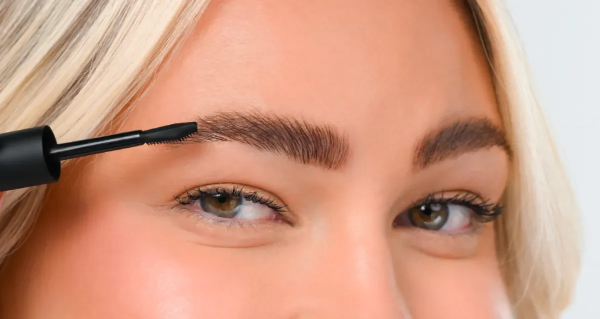 YOUNIQUE BARE·YOU eyebrow gel – where to buy : gel being applied with the black applicator on the brow of a blonde model with light eyes
