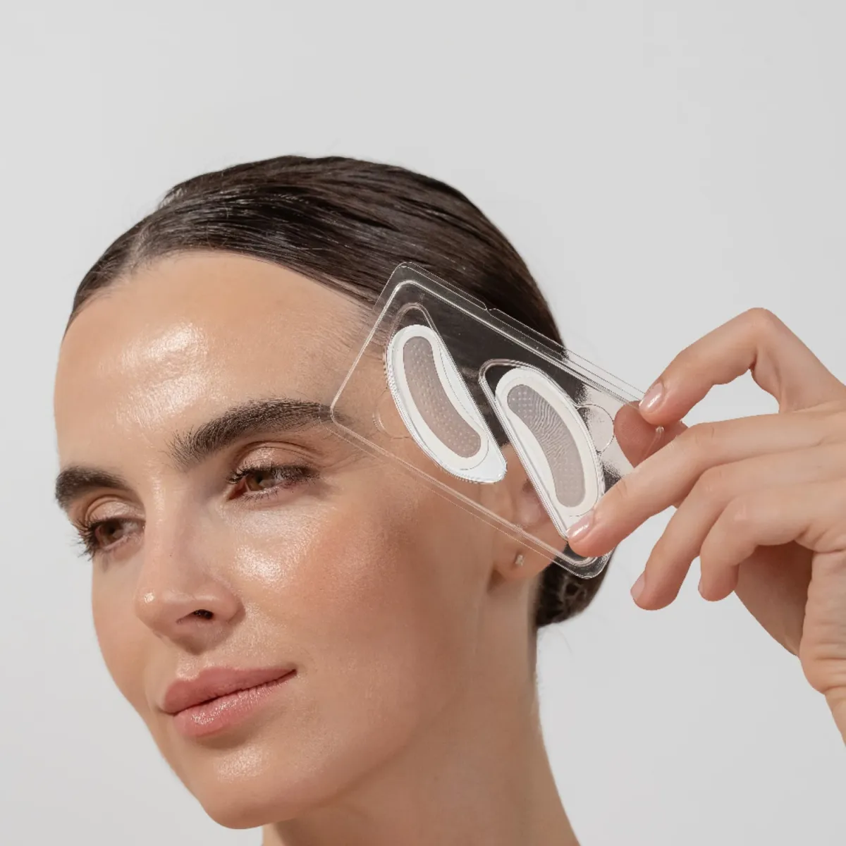 MICRO FUSE RETINOL-patchar för ansiktet – recension: kvinna som håller retinolpatchar för ansiktet