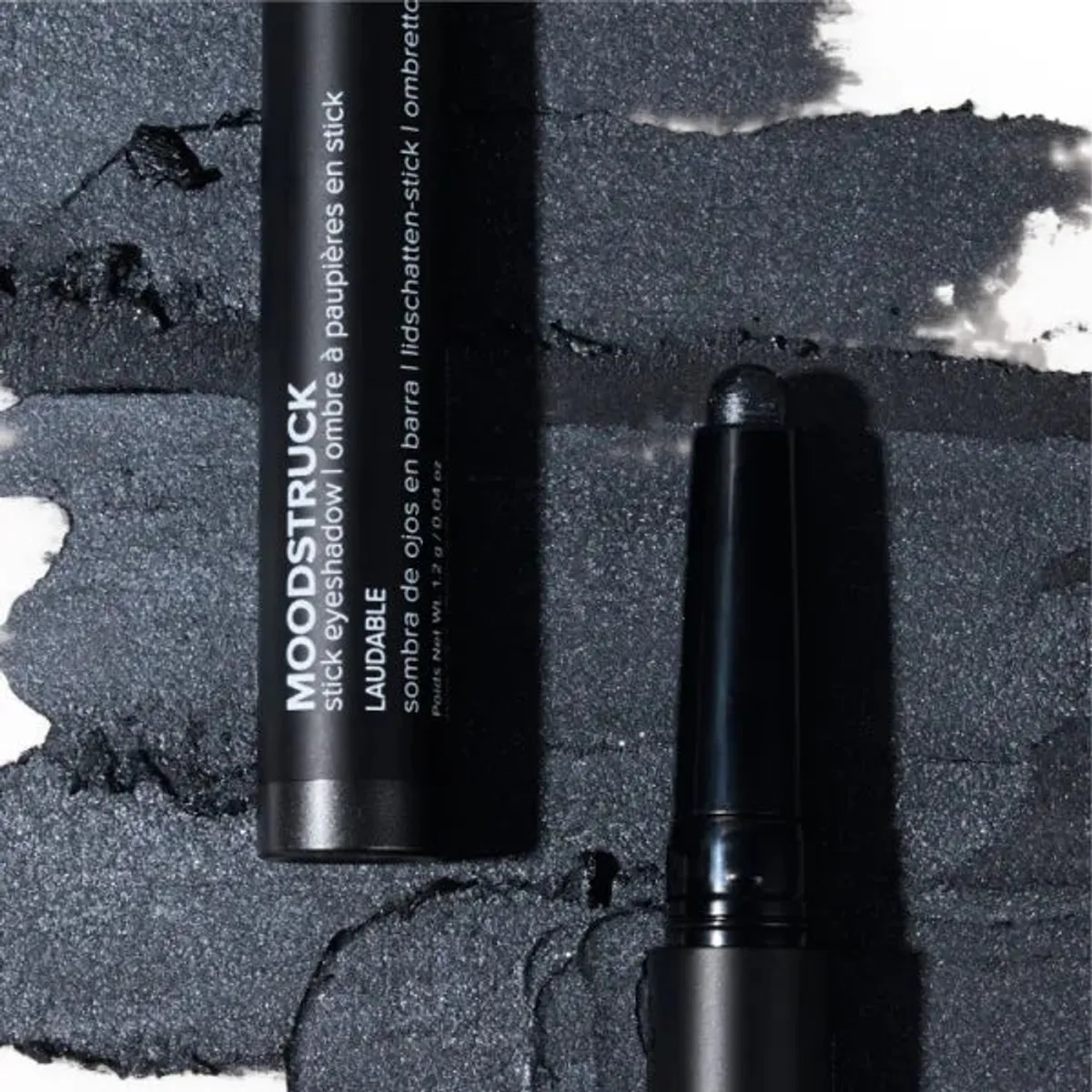 Younique MOODSTRUCK eyeshadow stick in Laudable, a shimmer charcoal grey shade: stick and colour swatch