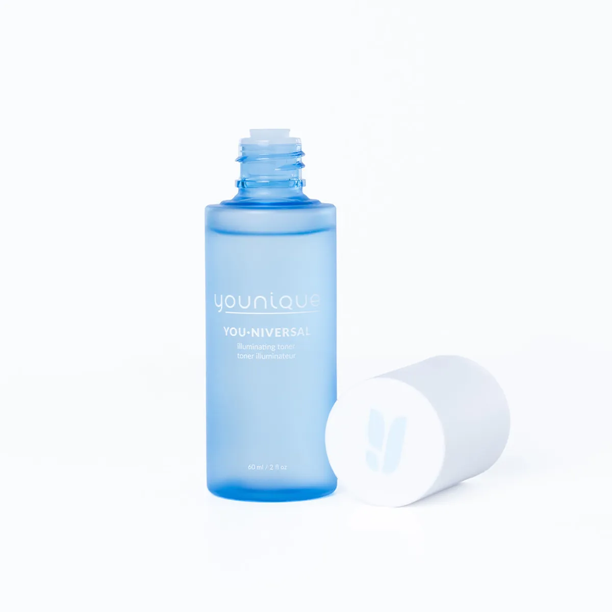 Toner illuminateur YOUNIQUE YOU·NIVERSAL – avis : flacon debout bouchon retiré, bouchon blanc posé à côté, sur fond clair